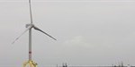 The picture shows a single offshore wind turbine